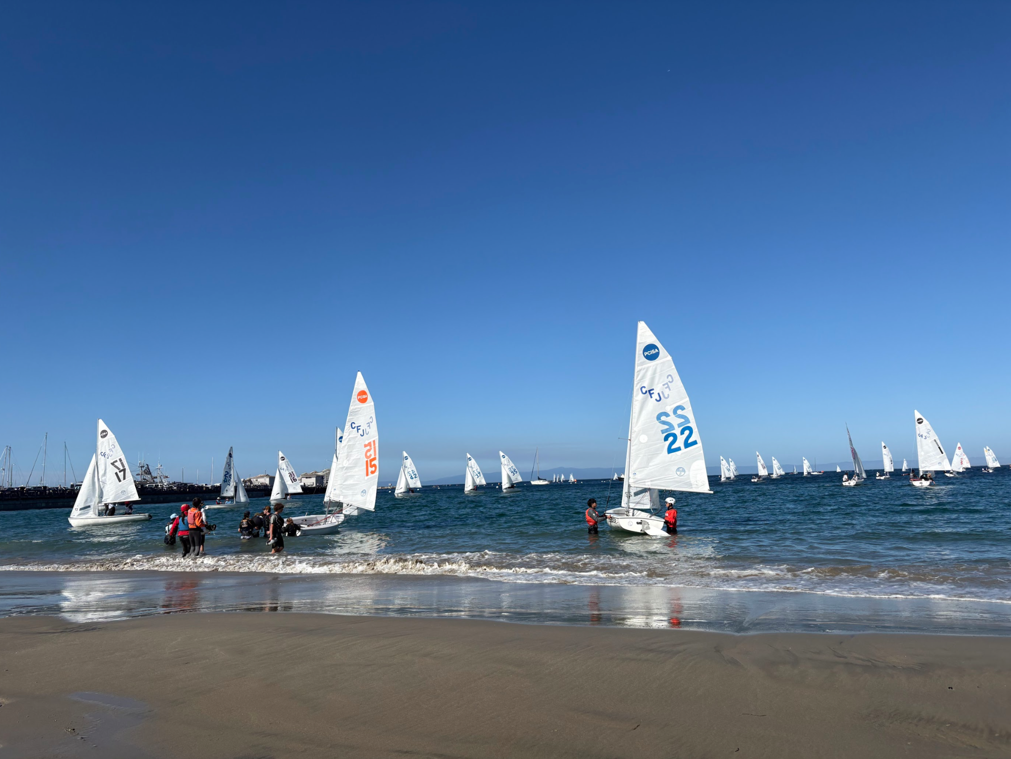 FJ sailboats launching from the beach at a regatta