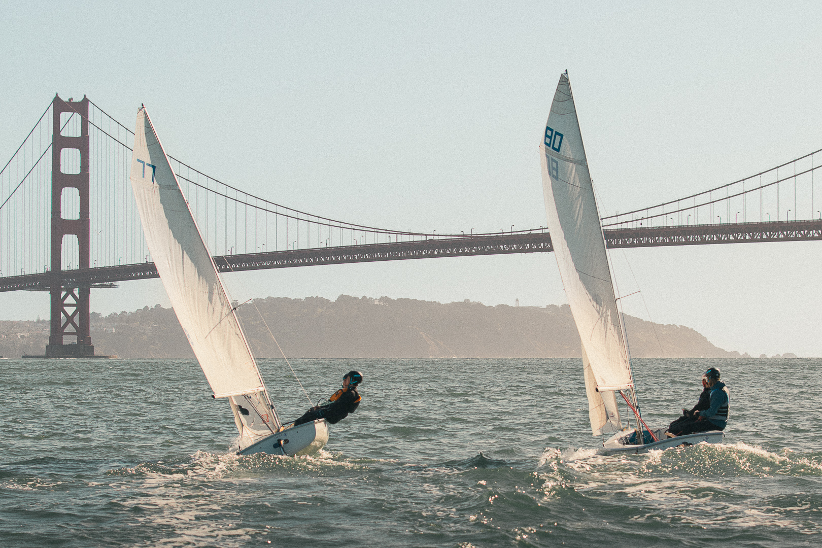 Two FJ sailboats sailing near the Golden Gate Bridge